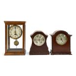 Three early 20th century mantel clocks, one in a glass case, 30cmH