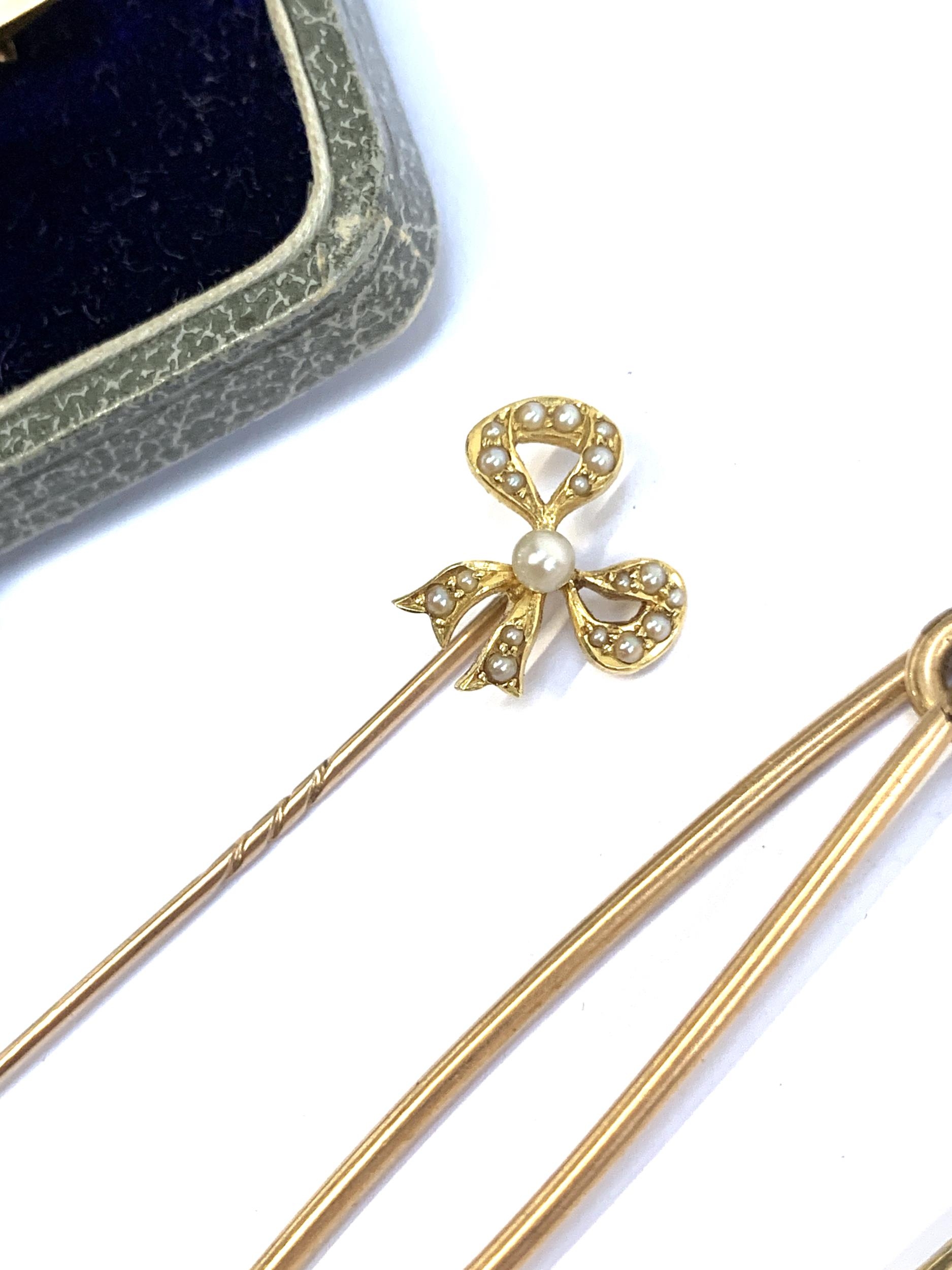 A 9ct gold Edwardian bar brooch set with a garnet, together with a yellow metal and seed pearl stick - Image 2 of 2