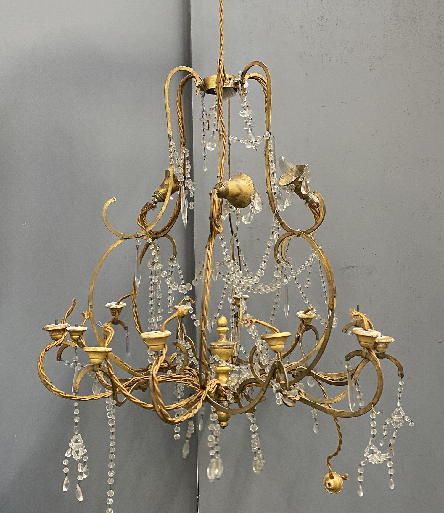 A gilt metal and glass drop 15 fitting chandelier, in need of restoration