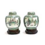 A pair of Chinese famille verte ginger jars depicting court scenes, 23.5cmH, on carved hardwood