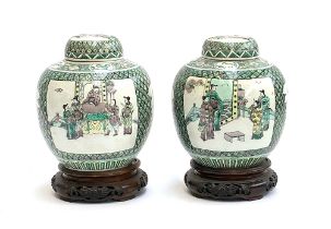 A pair of Chinese famille verte ginger jars depicting court scenes, 23.5cmH, on carved hardwood