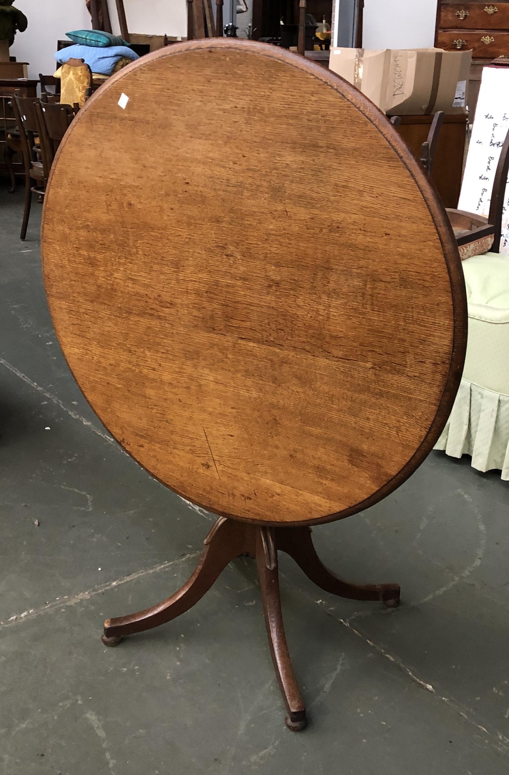 An early 20th century oak tip top tripod table, on four swept legs, 92x72cmH