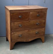 An early 19th century mahogany chest of two short over two long drawers, over a shaped apron, on