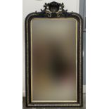 A large guilt and ebonised over mantle mirror, with shell cresting, 84x150cm