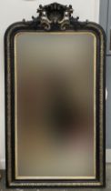 A large guilt and ebonised over mantle mirror, with shell cresting, 84x150cm