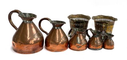 Five copper conical measures, quart to half gill, one with Devon mark; together with two pierced