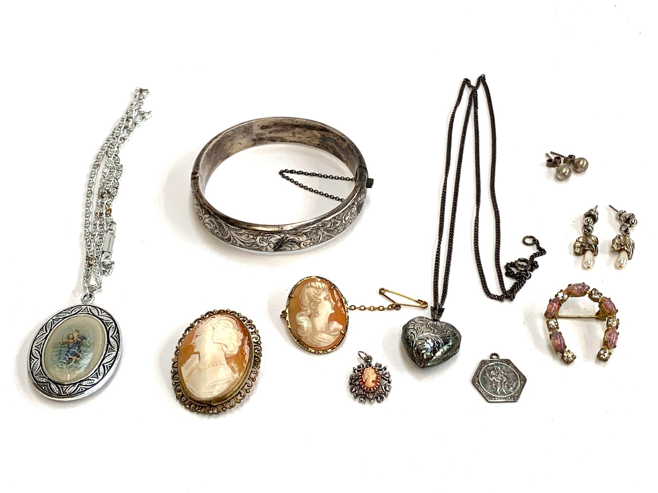 A small lot of jewellery to include silver bangle, St. Christopher, and puffy heart locket, gross