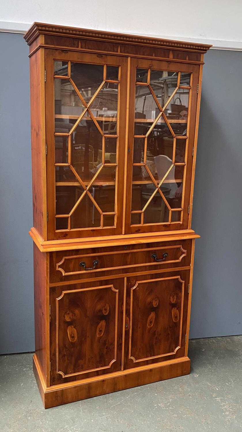 A 20th century yew veneer glazed bookcase, with single drawer and cupboards below, 95x39x200cmH