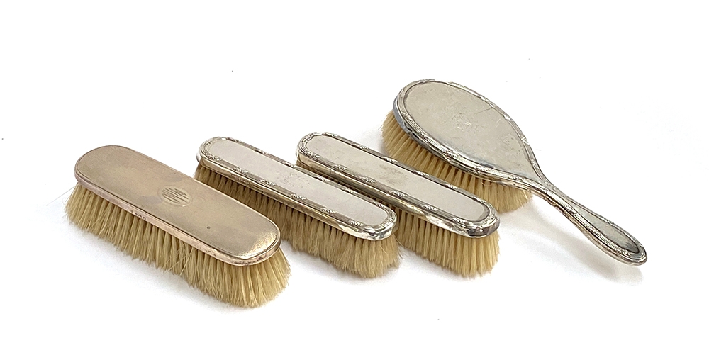 A pair of early 20th century silver backed clothes brushes and hair brush by Finnigans; together