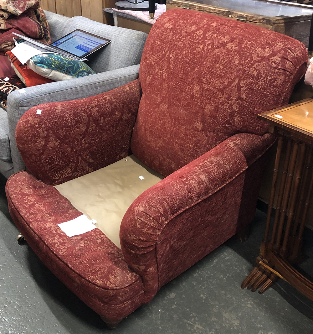 A Howard style armchair, on turned legs and brass casters, cushion missing