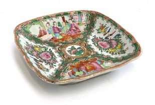 A Chinese famille rose dish of square form, four panels depicting court scenes and flora surrounding