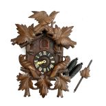 A carved cuckoo clock, with weights