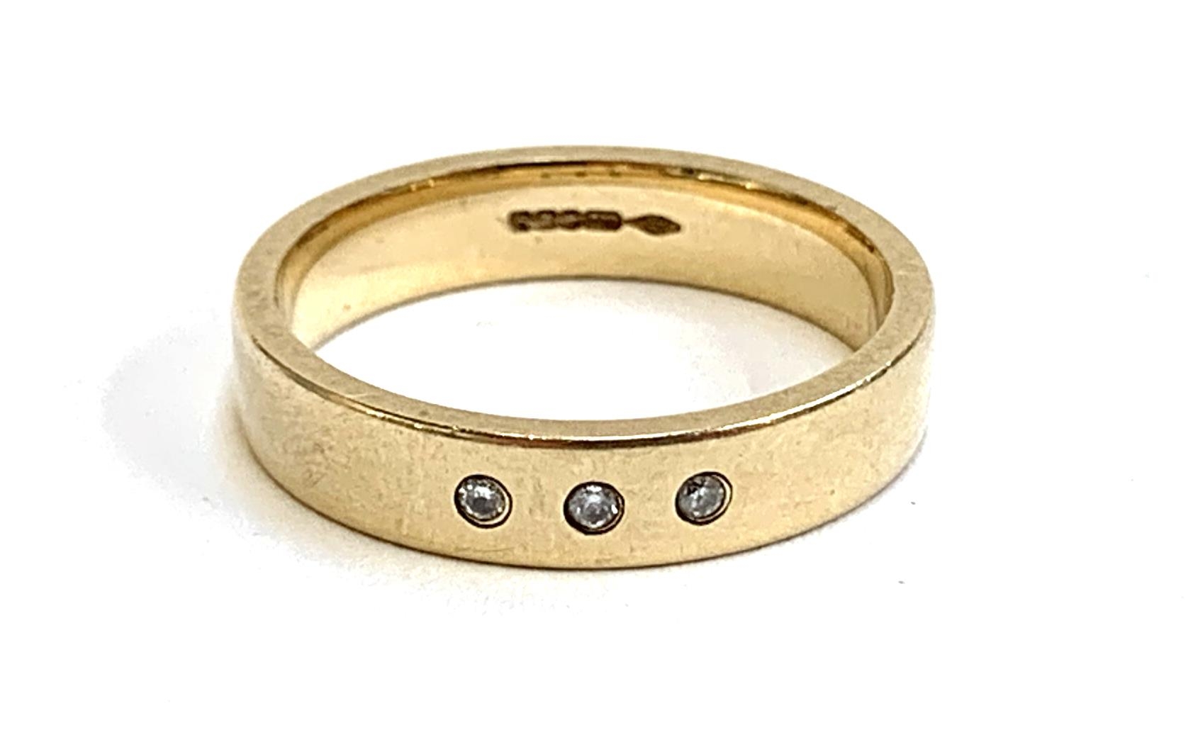 A 9ct gold band gypsy set with three small diamonds, size M, 3.4g