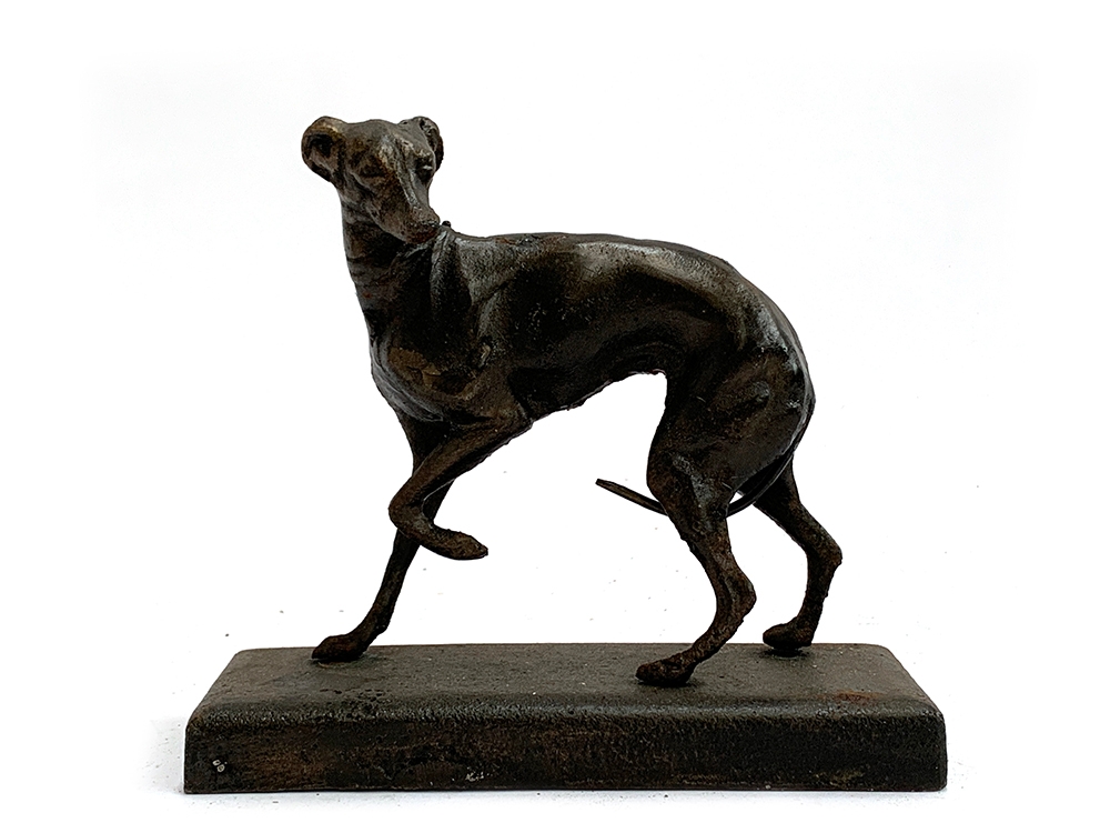 A cast metal figure of a whippet on plinth base, approx 17cmL