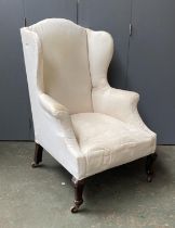 A Victorian wingback armchair, in need of reupholstery, carved front legs, 71cmW