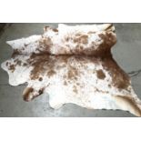 A brown cowhide rug, approx 127x226cm