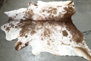 A brown cowhide rug, approx 127x226cm