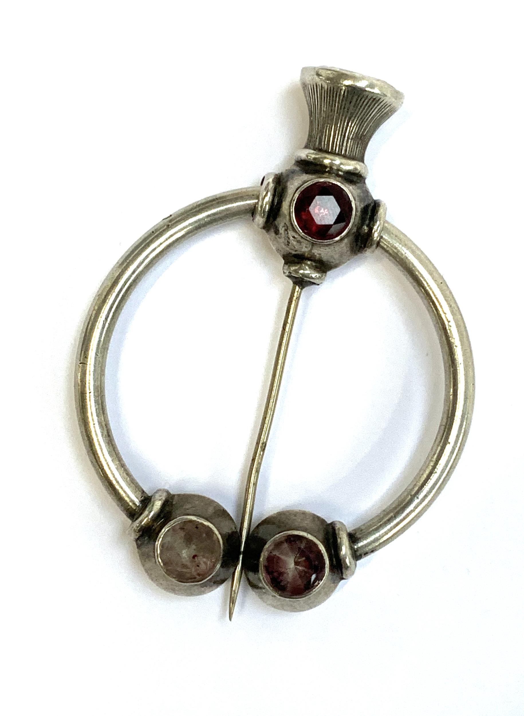 A Victorian silver Scottish penannular brooch set with foiled stones, with a thistle shaped pin