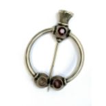 A Victorian silver Scottish penannular brooch set with foiled stones, with a thistle shaped pin