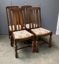 A set of four 20th century oak dining chairs with floral upholstered drop in seats