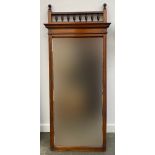 A late 19th early 20th century mahogany mirror with bevelled glass and turned spindles above,