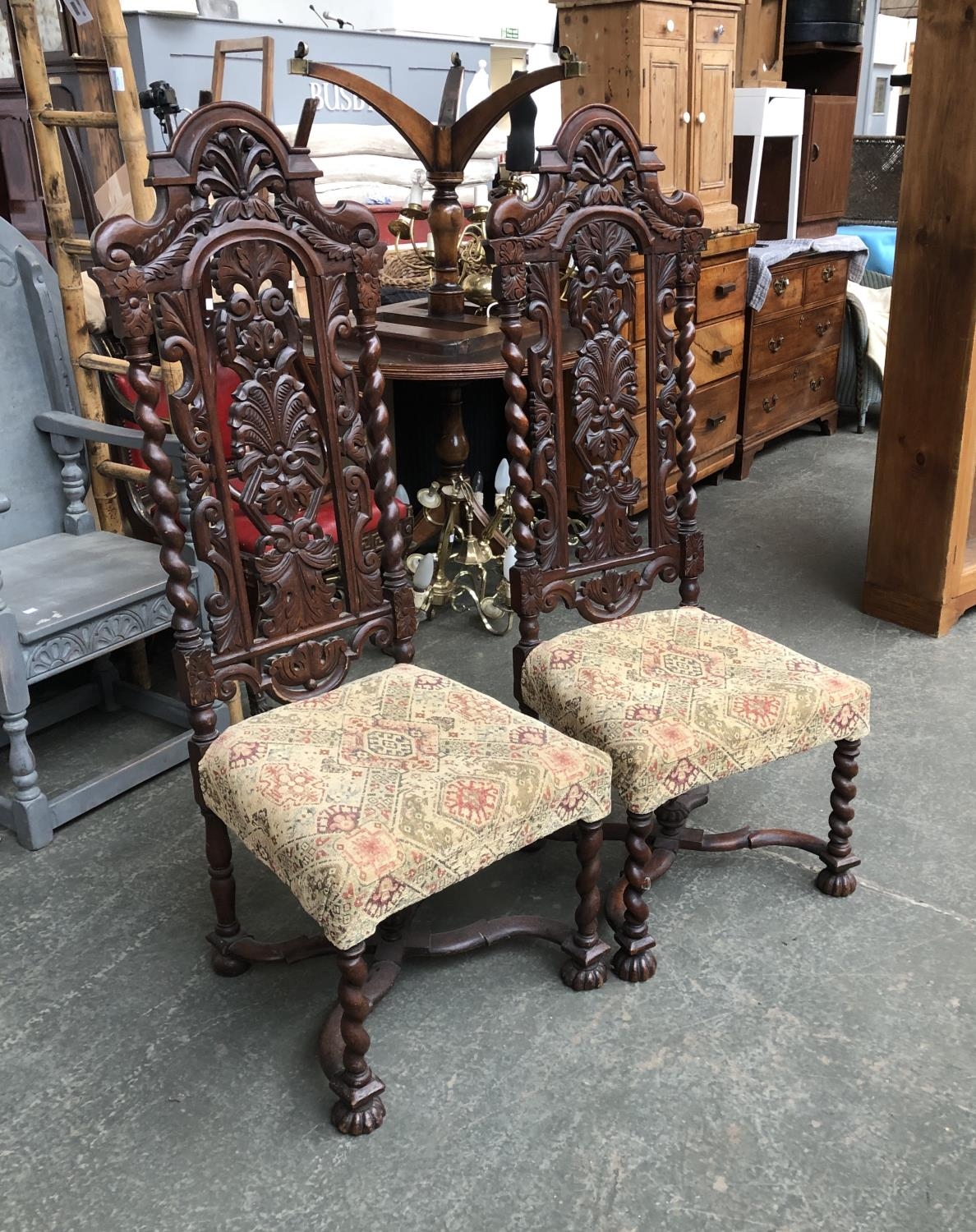 A pair of 19th century oak hall chairs, in Jacobethan taste, the carved backs with barleytwist