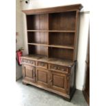 An oak dresser, the base with three drawers over panelled cupboards, 148x50x209cmH