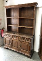 An oak dresser, the base with three drawers over panelled cupboards, 148x50x209cmH