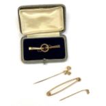 A 9ct gold Edwardian bar brooch set with a garnet, together with a yellow metal and seed pearl stick