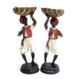 A pair of blackamoor figurines holding silvered shells, 28cmH