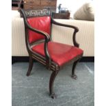 A Regency open armchair, the curved toprail with gilt Greek key motif, above a close nailed red