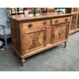An early 20th century sideboard with two drawers over two panelled doors with applied urn
