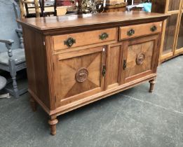 An early 20th century sideboard with two drawers over two panelled doors with applied urn