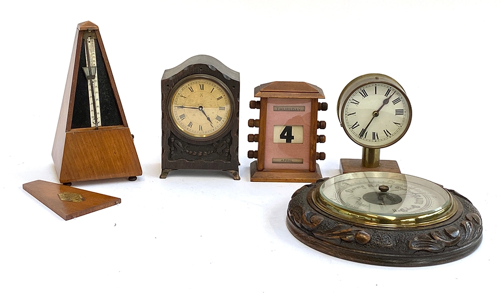 A Maelzel metronome; a early 20th century desk calendar; two clocks; and a carved aneroid barometer