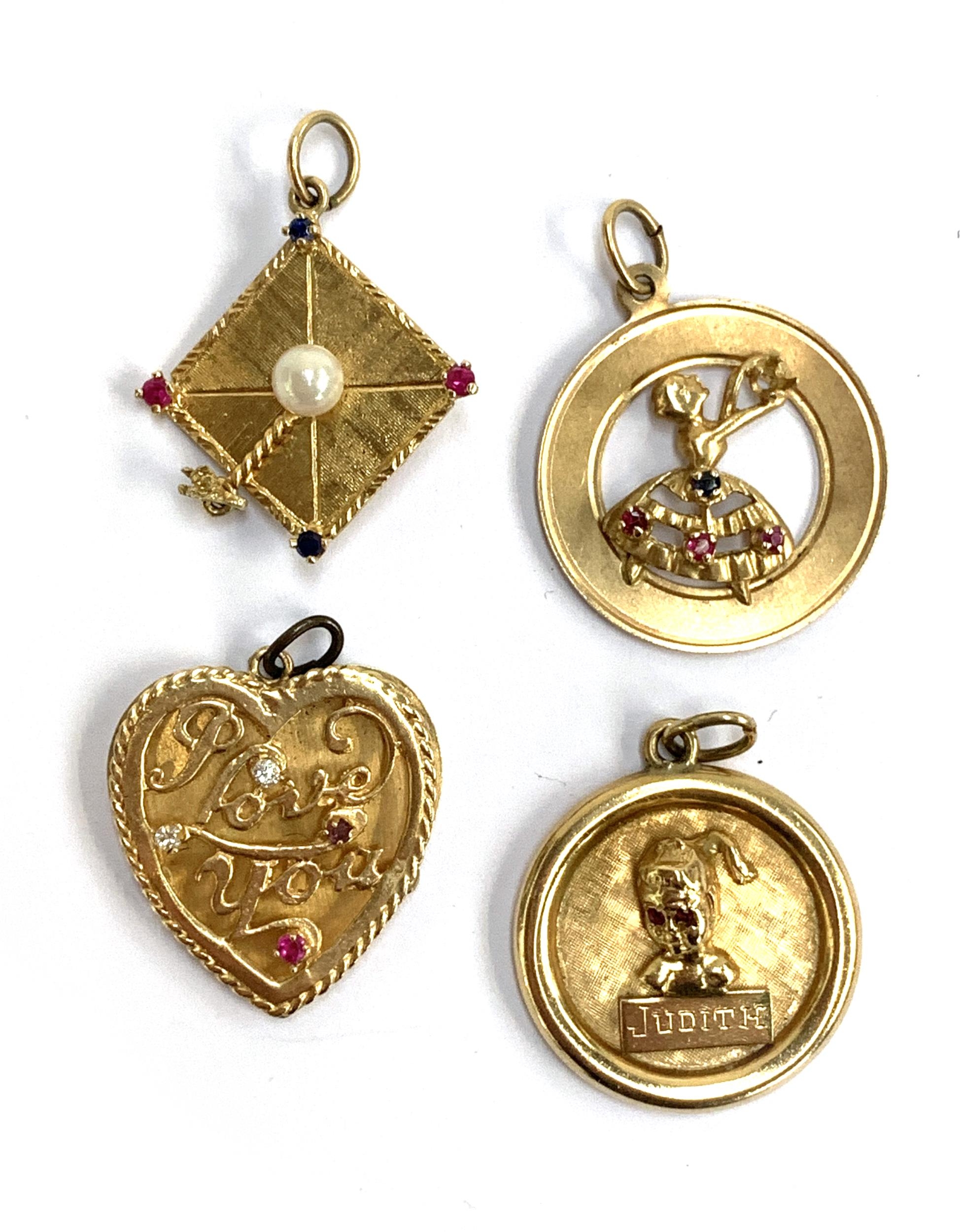 Four 14ct gold pendants, to include a mortar board, dancing lady set with sapphires and rubies, 'I