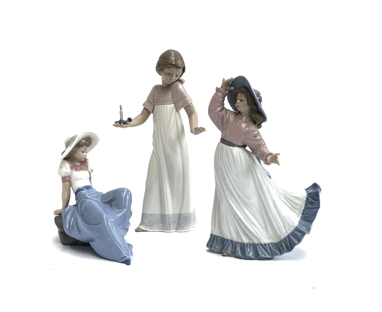 Three Nao by Lladro figures, girl holding candle, no. 1155, 26cmH, girl posing, no. 1391, girl