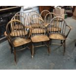 A set of nine beech and elm Ercol hoopback kitchen chairs, comprising two open armchairs, with