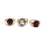 Three 9ct gold rings: one set with garnets size M, one synthetic ruby size L, the other green