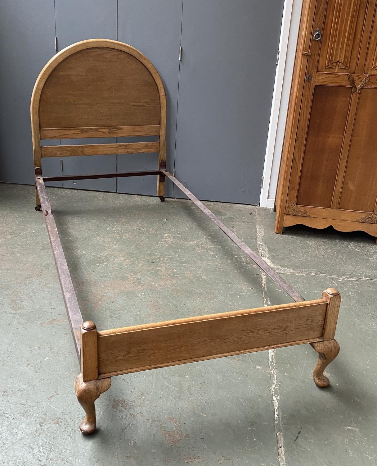 An oak single bed with domed headboard, 112cmH