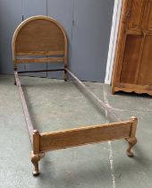 An oak single bed with domed headboard, 112cmH