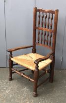 An ash spindle back open armchair, with low rush seat, the seat 33cmH