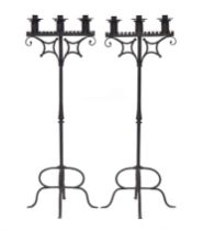 A pair of 19th century wrought iron ecclesiastical candlesticks, each with three nozzles, over