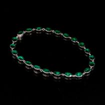 A 19th century silver mounted green paste riviere necklace, the emerald green paste in closed back