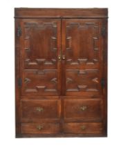 A 17th century oak livery cupboard, the panelled doors with applied geometric mouldings, opening