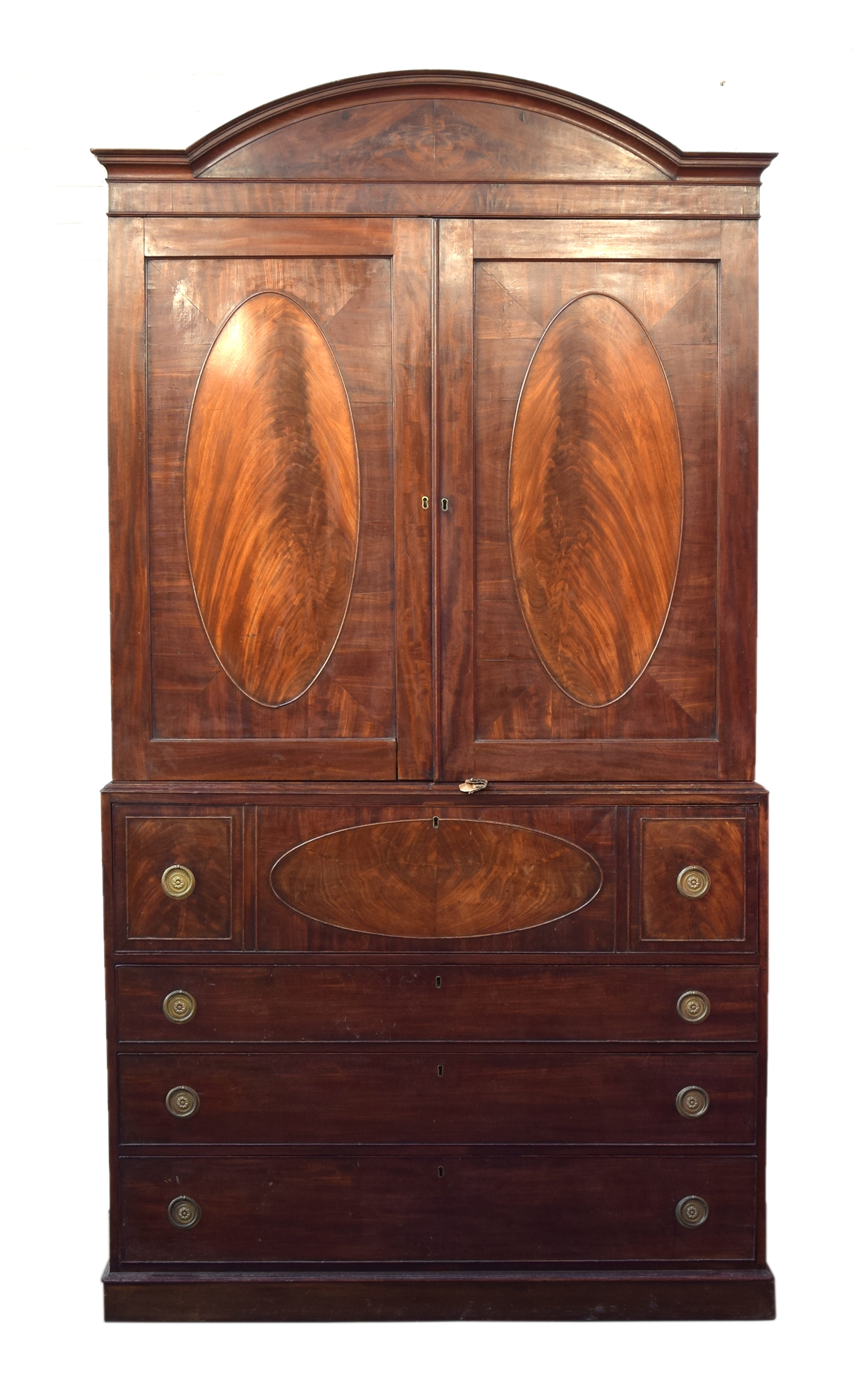 A 19th century clothes press, domed top over a pair of oval panelled doors, the base with four