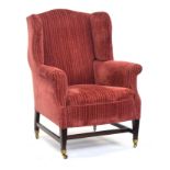 A wingback armchair in George III style, early 20th century, on square tapered legs joined by H