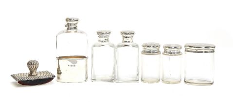 A lot of silver topped glass dressing table bottles, together with a matching flask with silver cup,