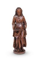 A late 18th/early 19th century North European carved walnut figure of a woman, robed and holding a