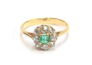 A late 19th/early 20th century emerald and diamond cluster ring, unmarked but tests as 18ct, the