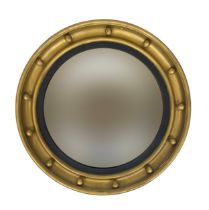 A Regency style circular convex mirror, cavetto ball moulding, with reeded ebonised slip, 62cm